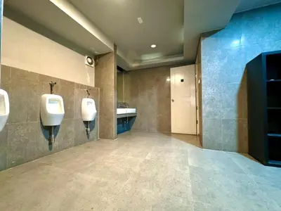 a bathroom with two white urinals and a sink at Collection O The Spades Hostel in Bangkok