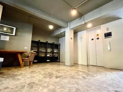 an empty room with a waiting room with a table and chairs at Collection O The Spades Hostel in Bangkok