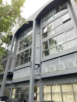 a building with a balcony on the side of it at Collection O The Spades Hostel in Bangkok