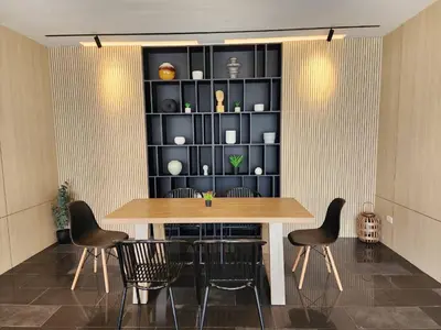 a dining room with a table and chairs and a shelf at Leenova Hotel in Bangkok