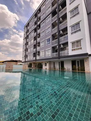 a swimming pool in front of a building at Leenova Hotel in Bangkok