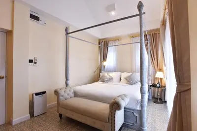 a bedroom with a four poster bed and a chair at Noursabah Boutique Bed Bangkok in Bangkok
