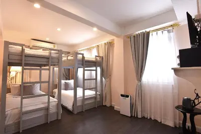 a bedroom with two bunk beds and a window at Noursabah Boutique Bed Bangkok in Bangkok