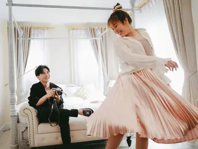 a man taking a picture of a woman in a dress at Noursabah Boutique Bed Bangkok in Bangkok
