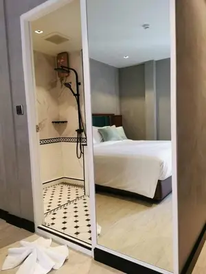 a bathroom with a shower and a bed in a room at Narawad Boutique Hotel in Bangkok