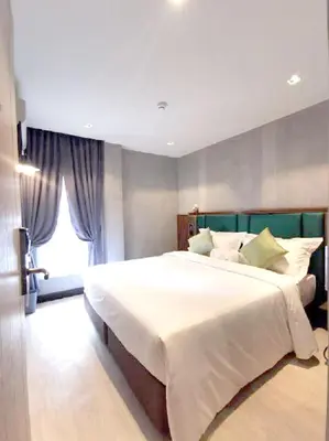 a bedroom with a large white bed with a window at Narawad Boutique Hotel in Bangkok