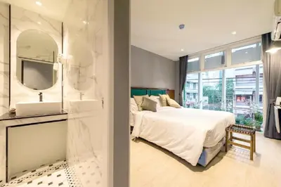 a bedroom with a bed and a sink and a mirror at Narawad Boutique Hotel in Bangkok