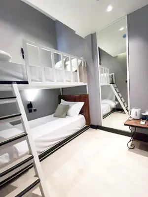 a bedroom with bunk beds with a mirror and a desk at Narawad Boutique Hotel in Bangkok