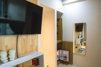 a room with a flat screen tv on a wall at BoB Hostel บ็อบโฮสเทล in Bangkok