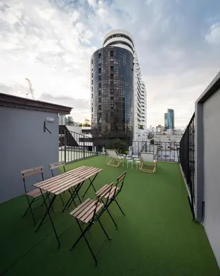 a balcony with tables and chairs on a building at BoB Hostel บ็อบโฮสเทล in Bangkok
