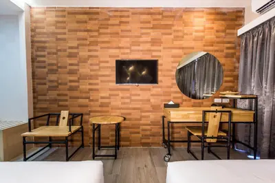 a room with tables and chairs and a brick wall at Villa Baron SHA PLUS in Nonthaburi