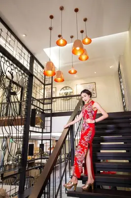 a woman in a red dress walking down stairs at Villa Baron SHA PLUS in Nonthaburi