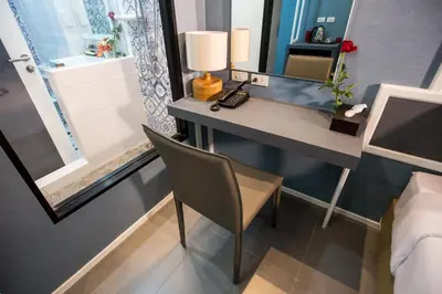 a bedroom with a desk with a lamp and a mirror at Villa Baron SHA PLUS in Nonthaburi