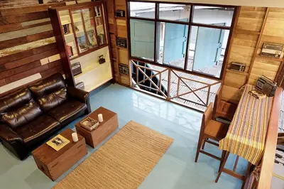 a living room with a leather couch and a chair at Sor Vorapin Muay Thai Home in Bangkok