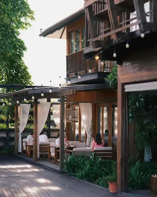 a restaurant with people sitting at tables in front of a building at Chann Bangkok Noi in Bangkok