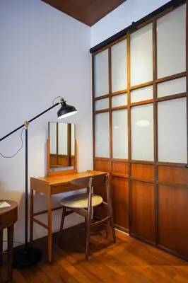 a desk with a chair and a lamp in a room at Chann Bangkok Noi in Bangkok