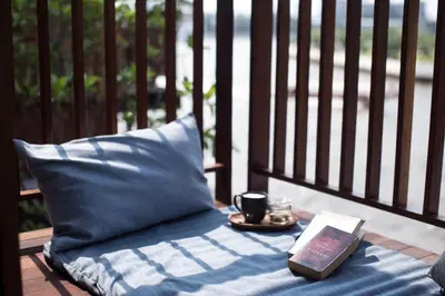 a table with a pillow and a plate with a book at Chann Bangkok Noi in Bangkok