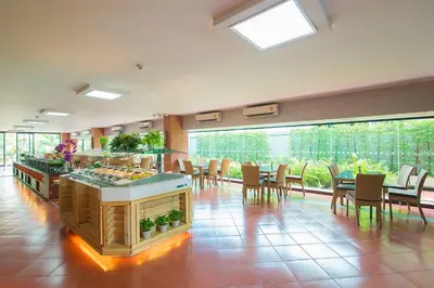 a large room with tables and chairs and a kitchen at Baan Thai Boutique in Bangkok