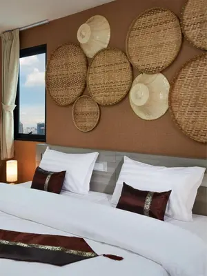 a bedroom with a large bed with baskets on the wall at Baan Thai Boutique in Bangkok
