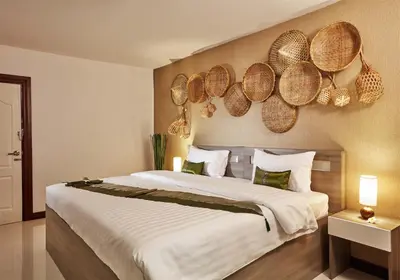 a bedroom with a large bed with baskets on the wall at Baan Thai Boutique in Bangkok