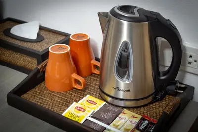 a tray with a tea kettle and two orange cups at Baan Thai Boutique in Bangkok