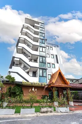a tall white building in front of a building at Baan Thai Boutique in Bangkok