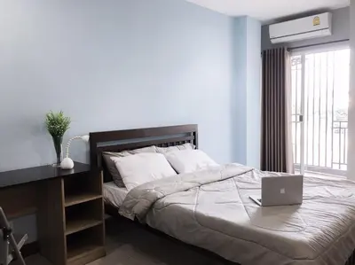 a bedroom with a bed with a laptop on it at โรงแรม เดอะริช ราชพฤกษ์ โฮเทล แอนด์ เรสซิเดนซ์ in Nonthaburi