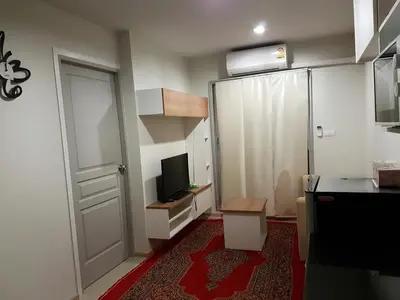 a small kitchen with a door and a television at Rich Park@Tao poon interchange in Bang Su