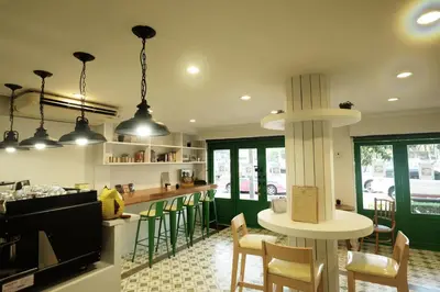 a kitchen with a bar with chairs and a table at Ratana Boutique Hostel in Bangkok