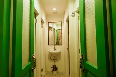 a bathroom with green and white walls and a sink at Ratana Boutique Hostel in Bangkok