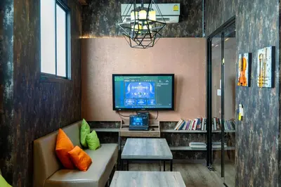 a living room with a couch and a tv at The Printing House Poshtel in Bangkok