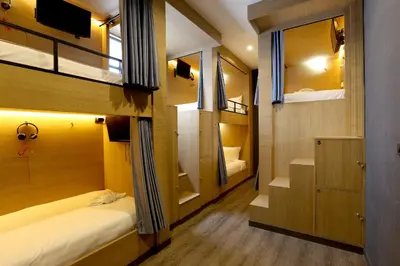 a small room with two bunk beds and a staircase at The Printing House Poshtel in Bangkok