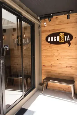 a store front with a bench in front of a window at Augusta in Bangkok