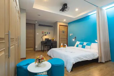 a hotel room with a large bed and a desk at Augusta in Bangkok