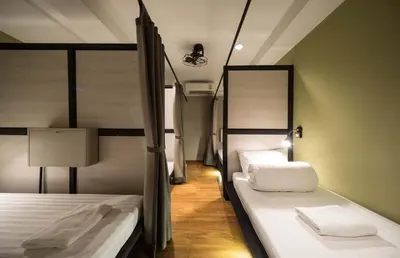 a room with two beds and a lamp in it at Augusta in Bangkok