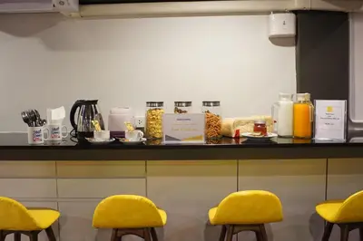 a counter with yellow chairs in a kitchen at BRB Hostel Bangkok Silom in Bangkok