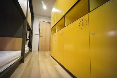 a hallway with yellow lockers and a bed in a room at BRB Hostel Bangkok Silom in Bangkok