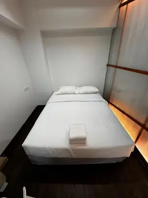 a large white bed in a small room at Glur Central Pratunam in Bangkok