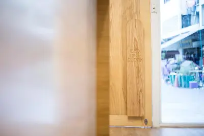 a wooden door with a sign on the side of it at Bed One Block Hostel in Bangkok