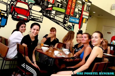a group of women sitting at a table in a restaurant at Siri Poshtel Bangkok in Bangkok