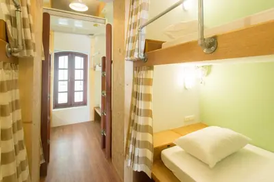 a small room with a bunk bed and a window at Barn & Bed Hostel in Bangkok