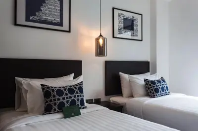 a bedroom with two beds and a pendant light at Oriental Heritage Hotel in Bangkok