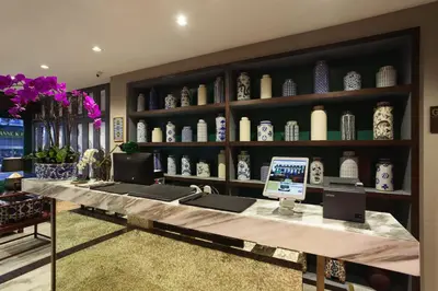 a room with a desk with vases on shelves at Oriental Heritage Hotel in Bangkok