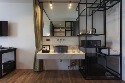a bathroom with a sink and a large mirror at Oriental Heritage Hotel in Bangkok