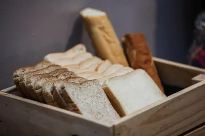 a wooden container filled with slices of bread and breadsticks at Oriental Heritage Hotel in Bangkok
