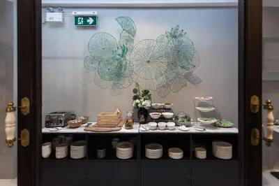 a display cabinet with plates on it with umbrellas on the wall at Oriental Heritage Hotel in Bangkok