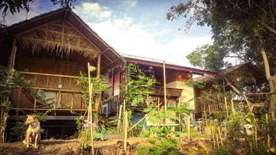 a house with a dog standing in front of it at Cast Away in Nonthaburi