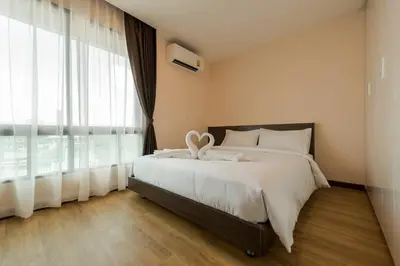a bedroom with a bed and a large window at Zensation The Residence in Bangkok