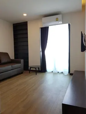 a living room with a couch and a window at Zensation The Residence in Bangkok