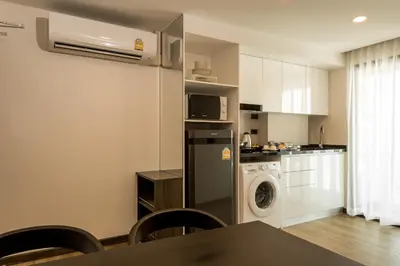 a kitchen with a refrigerator and a washing machine at Zensation The Residence in Bangkok